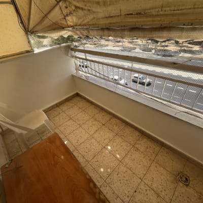 מרפסת עם כיסא פלסטיק ושולחן עץ