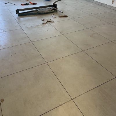 חדר עם רצפה מרוצפת, כלי עבודה ודלי כחול