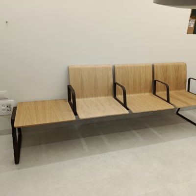 שלושה כיסאות עץ עם מסגרות מתכת בחדר המתנה