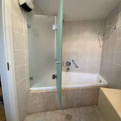 אמבטיה עם דלת זכוכית חלבית ומקלחת