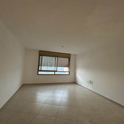 חדר ריק עם קירות לבנים ורצפת אריחים