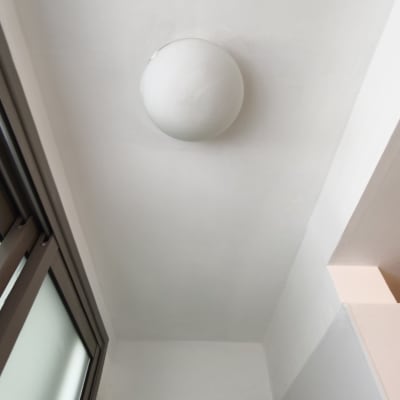 מנורה עגולה מותקנת על תקרה לבנה ליד חלון