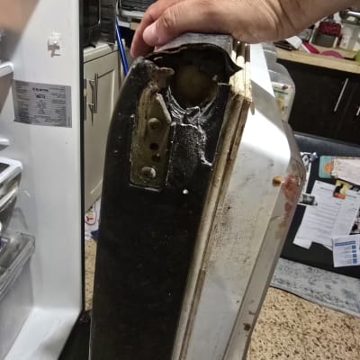דלת מקרר פגומה עם יד אוחזת בה