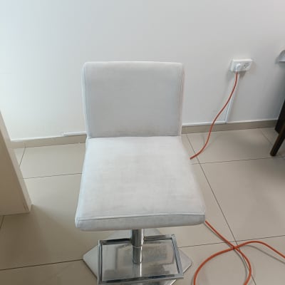 כיסא לבן על רצפה עם כבל כתום לידו