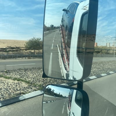 מכונית על גרר במראה צדדית של משאית