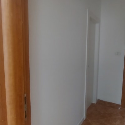 קיר מסויד עם דלת עץ ורצפת אריחים