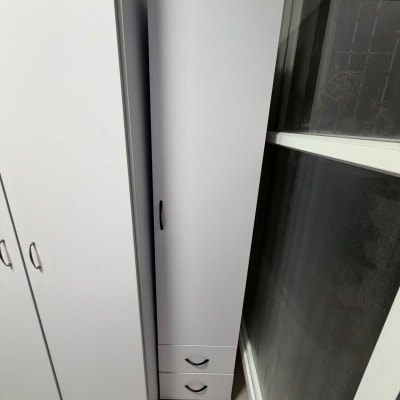 ארון לבן עם ידיות שחורות ליד חלון