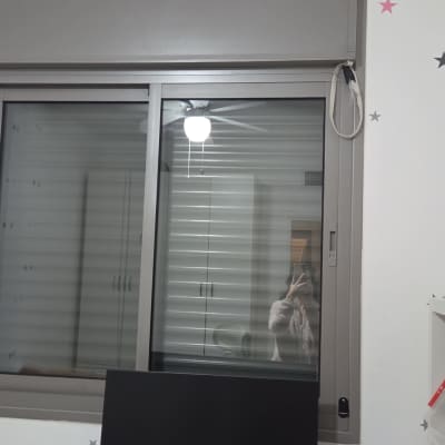 חלון עם תריסים סגורים ומחשב שולחני