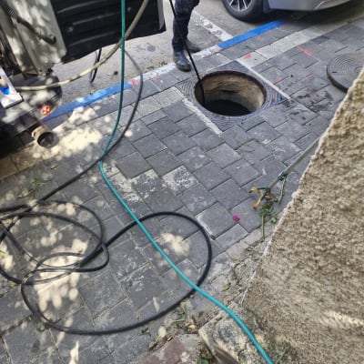משאית שואבת ליד פתח ביוב ברחוב