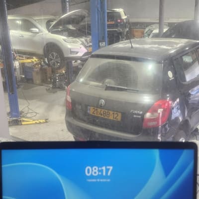 מוסך עם רכבים על ליפטים, מסך מחשב פתוח