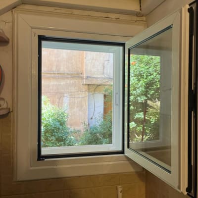 חלון אלומיניום פתוח עם מסגרת לבנה