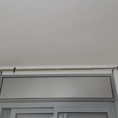 מוט וילון מותקן מעל חלון עם סוגרים