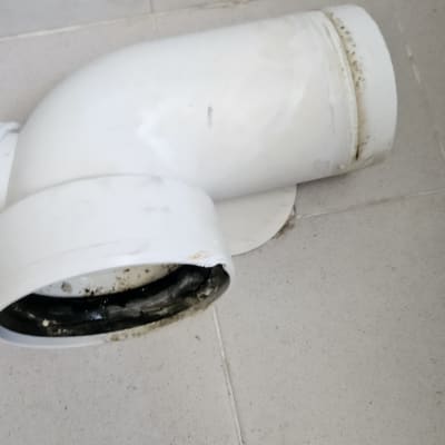 צינור לבן עם חיבורי ביוב על רצפת קרמיקה