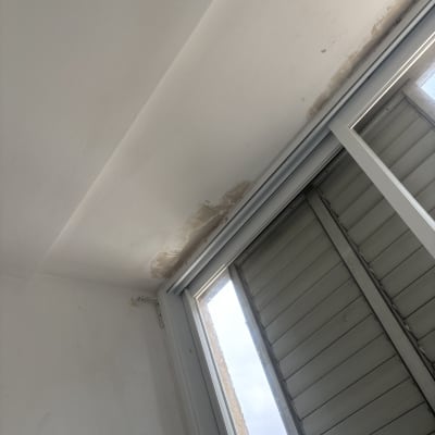 קיר עם סימני רטיבות ליד חלון