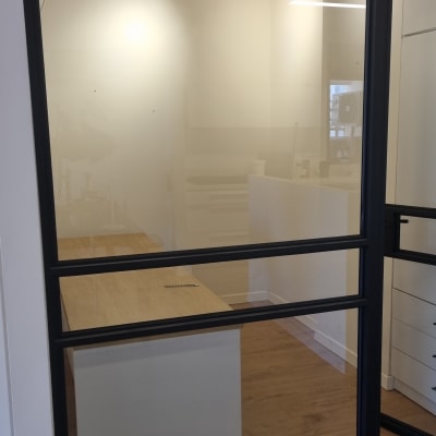 חדר עם דלת זכוכית ומסגרת מתכת שחורה