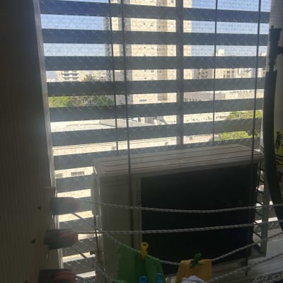 רשת יונים מותקנת על חלון עם תריסים פתוחים