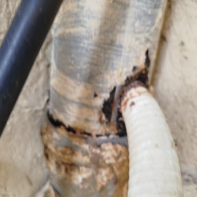 צינורות פגומים עם חלודה על קיר חיצוני