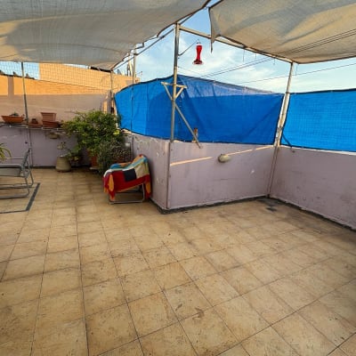 מרפסת עם צמחים וריהוט חוץ, כיסוי שמש כחול