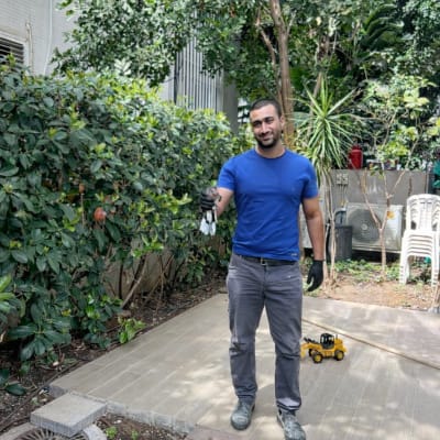 אדם עומד בגינה עם צעצועים על הקרקע