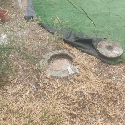 פתח ביוב פתוח עם מכסה מונח בצד