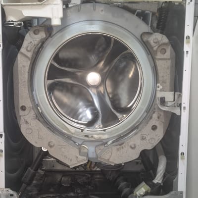 מכונת כביסה פתוחה עם תוף חשוף וחלקים פנימיים