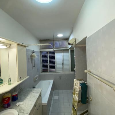 סולם צבוע בצבע לבן ליד קיר בחדר אמבטיה