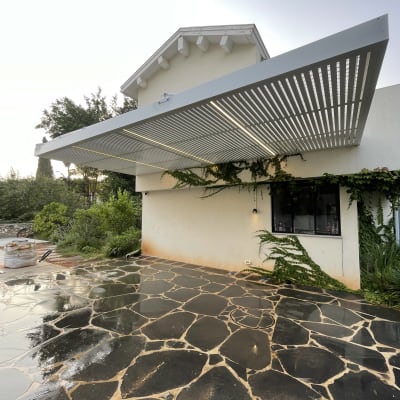 פרגולה מאלומיניום מחוברת לבית עם גג רעפים