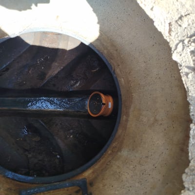 צינור ביוב עם מחבר כתום בתוך בור