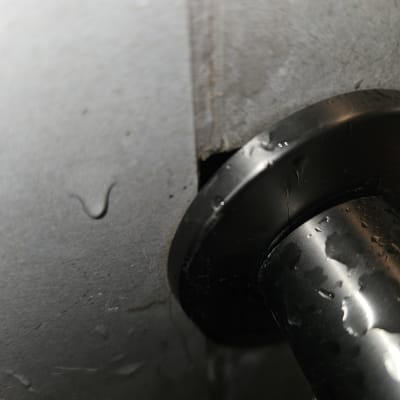 צינור מתכת עם סימני נזילה על קיר