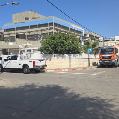 אתר בנייה עם פיגומים ומשאיות