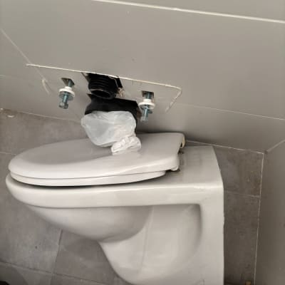 אסלה מותקנת עם חיבורי צנרת גלויים