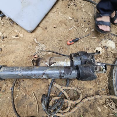 צינור מתכת חלוד עם כלי עבודה על הקרקע