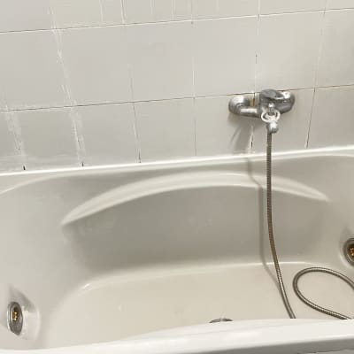 אמבטיה עם אריחים לבנים וברז מתכת