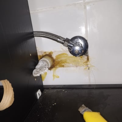 צינור מתכת מחובר לקיר עם חיבורי אינסטלציה