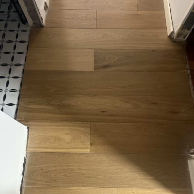 רצפת פרקט עץ במסדרון עם קיר לבן