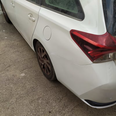 חלק אחורי של רכב לבן עם גלגלים כהים