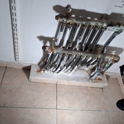 צינורות מתכת מחוברים לקיר עם חלודה