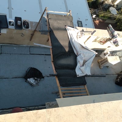 עבודת איטום על גג עם כלים וחומרים