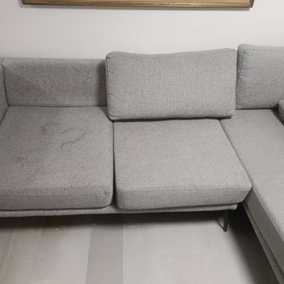 ספה אפורה עם כתמים קלים על המושב