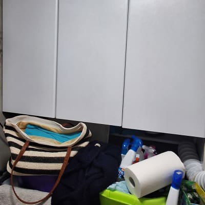 מוצרי ניקוי ומגבות על מדף במטבח