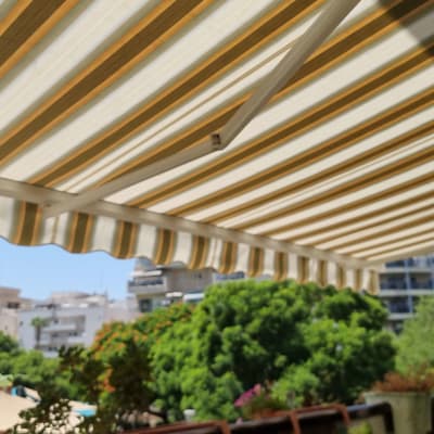 סוכך פסים צהובים ולבנים על רקע שמיים כחולים