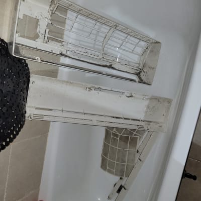 חלקי מזגן מפורקים באמבטיה לניקוי