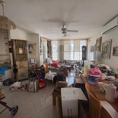 חדר מבולגן עם קופסאות וציוד לניקיון