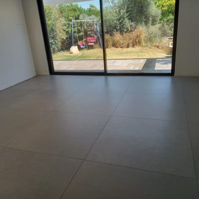 רצפה נקייה עם אריחים גדולים ליד חלון זכוכית