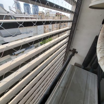 רשת יונים מותקנת על מרפסת בבניין מגורים