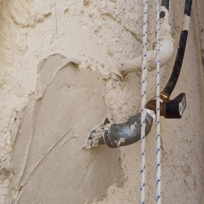 צינור מתכת עם חיבורי ברז על קיר