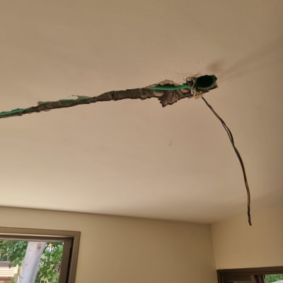 חוטי חשמל יוצאים מתקרה עם חור