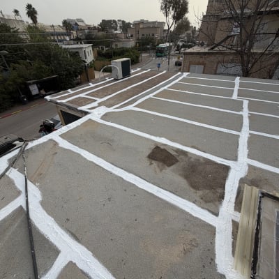 גג עם איטום לבן על רקע עירוני