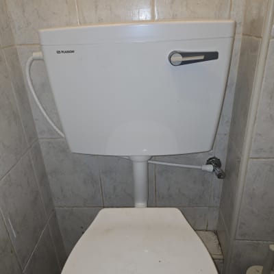 אסלה עם מיכל הדחה בחדר אמבטיה