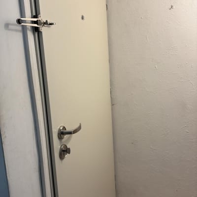 דלת לבנה עם ידית מתכת בחדר קטן